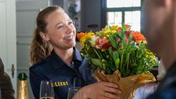Sophia Strasser (Katharina Leonore Goebel) wird im Revier mit einem Blumenstrauß willkommen geheissen.