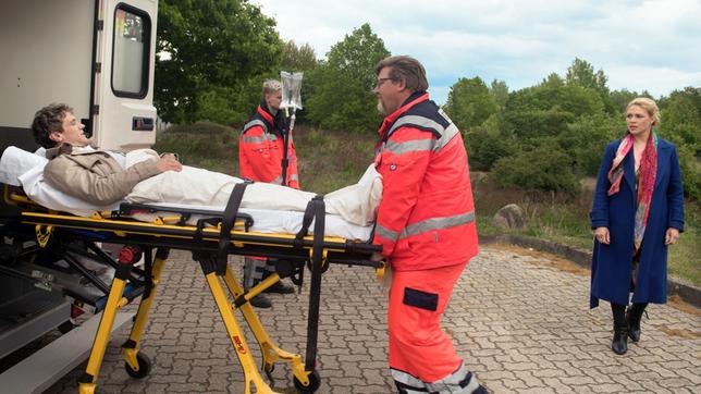 Bild: ARD/Nicole Manthey Britta (Jelena Mitschke) ruft für Luke (Oliver Franck) den Notruf, begleitet ihn aber nicht ins Krankenhaus (mit Komparsen).