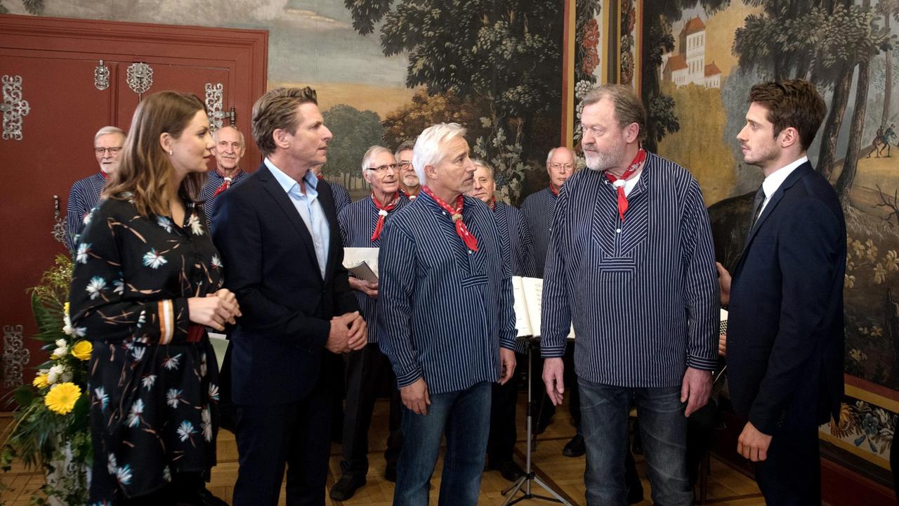 Bruno (Wolfgang Häntsch) beschimpft seinen Bruder Henning (Herbert Ulrich) bei einem Empfang im Rathaus vor den versammelten Gästen und nennt ihn einen Mörder. Alex (Philipp Oliver Baumgarten), Thomas (Gerry Hungbauer) und Judith (Katrin Ingendoh, l. mit Komparsen, h.) sind entsetzt.