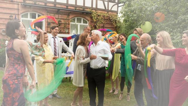 Bild: ARD/Nicole Manthey Die Vergiftung hat Thomas (Gerry Hungbauer) in eine Wahnwelt abdriften lassen. In seinem Traum feiert er einen harmonischen Geburtstag mit Petra (Angela Roy) und seinen Lieben (v.l.n.r.: Samantha Viana, Brigitte Antonius, Frederic Böhle, Joachim Ketzer, Jelena Mitschke, Anja Franke, Hakim Michael Meziani, Claus Dieter Clausniter, Kim-Sarah Brandts und Cheryl Shepard).
