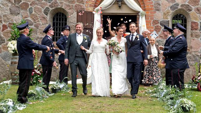 Bild: ARD/Nicole Manthey Doppelhochzeit: Die Hochzeitspaare Jens (Martin Luding) und Mona (Jana Hora-Goosmann) sowie Tatjana (Judith Sehrbrock) und Paul (Leander Lichti) schreiten aus der Kirche, wo sie von ihren Freunden empfangen werden (mit Thore Lüthje h.M., Gerry Hungbauer, 4.v.r., Jelena Petrenko, 3.v.r. und Komparsen).