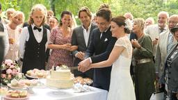 Doppelhochzeit: Paul (Leander Lichti, vorne) und Tatjana (Judith Sehrbrock, vorne) schneiden vor ihren Gästen die Hochzeitstorte an (mit Katja Frenzel, 3.v.l., Hakim Michael Meziani, 4.v.l. und Komparsen).