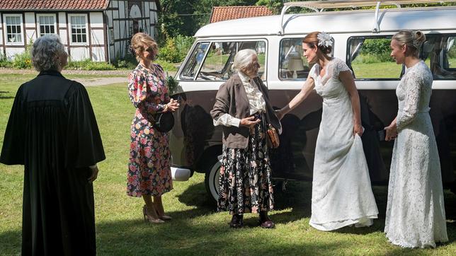 Doppelhochzeit: Tatjana (Judith Sehrbrock) ist überglücklich, dass ihre Großmutter Babuschka (Maria Mägdefrau) zur Hochzeit kommen konnte. Dörte (Edelgard Hansen), Sara (Antonia Jungwirth) und Mona (Jana Hora-Goosmann) begrüßen den Überraschungsgast herzlich.