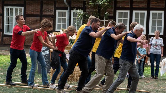 Bild: ARD/Nicole Manthey Gregor (Wolfram Grandezka), Sonja (Madeleine Niesche), Eva (Andrea Lüdke), Tilmann (Björn Bugri), Gunter (Hermann Toelcke) und Thomas (Gerry Hungbauer) wetteifern bei der Erntedank-Olympiade um die beste Platzierung (mit Komparsen, hinten).