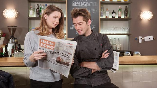 Judith (Katrin Ingendoh) zeigt Alex (Philipp Oliver Baumgarten) die Pressekritik über das neu benannte "Stint".