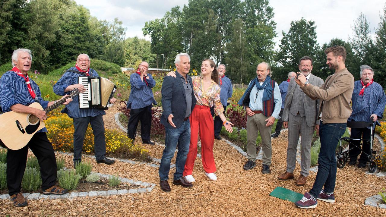 Thomas (Gerry Hungbauer) ist gerührt von dem herzlichen Abschied. Er wird Jule (Kim Sarah Brandts) nach Brasilien begleiten. Hannes (Claus Dieter Clausnitzer), Gunter (Hermann Toelcke) und Simon (Thore Lüthje) verabschieden Thomas gebührend, mit dem Gesang des Shanty-Chors aus Lüneburg.