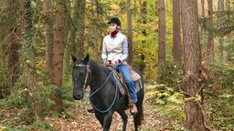 Miriam reitet durch einen Wald