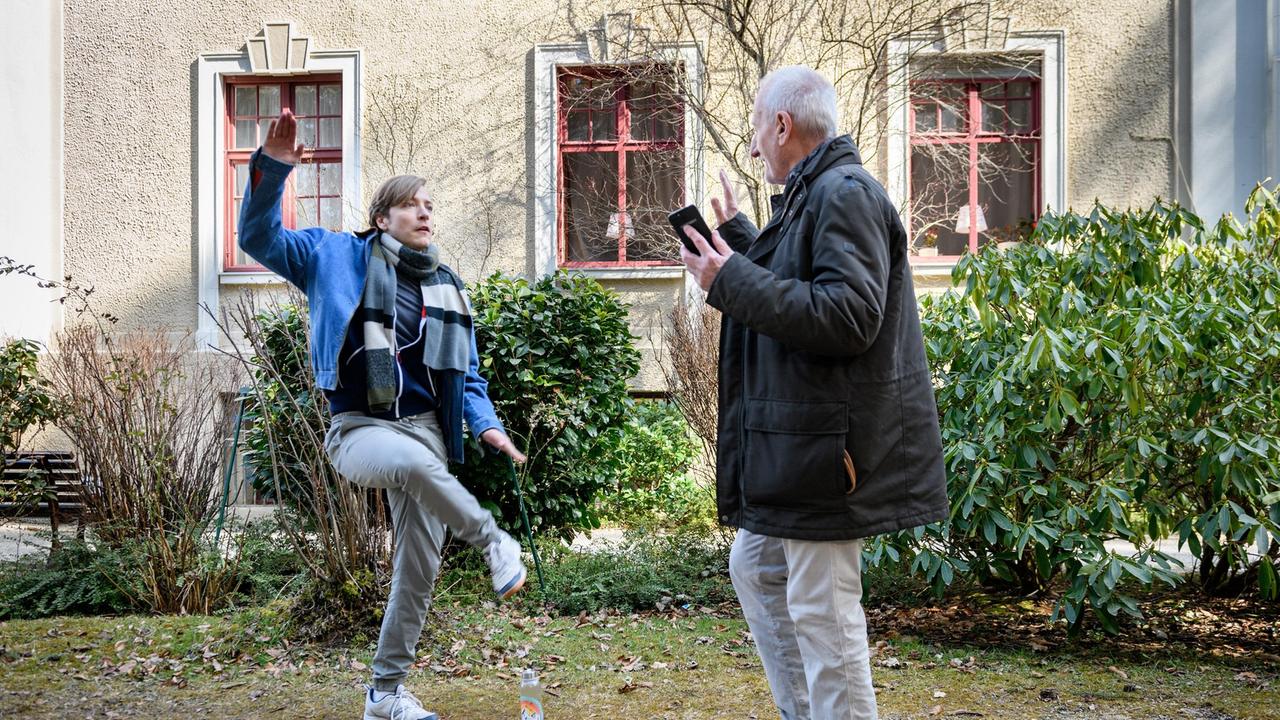 Alfons (Sepp Schauer) zeigt Gerry (Johannes Huth), wie man schuhplattelt.