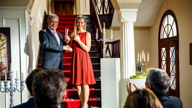 André (Joachim Lätsch) überreicht Luisa (Magdalena Steinlein) den Kosmetik-Award.