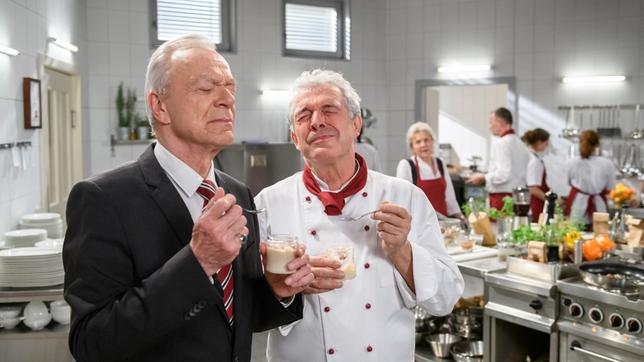 Bild: ARD/Christof Arnold André (Joachim Lätsch) und Werner (Dirk Galuba) kosten vom selbstgekochten Babybrei für Luna (mit Antje Hagen, h.l. und Komparsen).