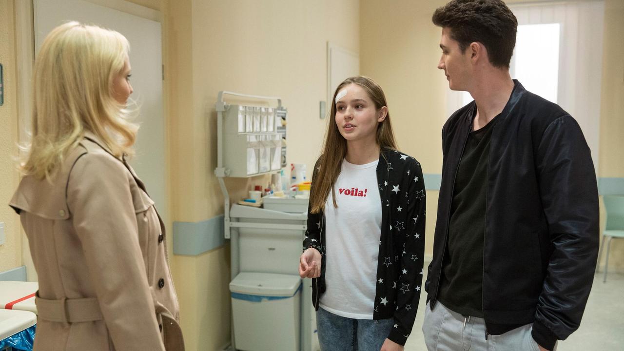 Annabelle (Jenny Löffler) stutzt, als sie Valentina (Paulina Hobratschk) und Fabien (Lukas Schmidt) im Krankenhaus trifft.