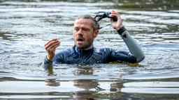 Beim Tauchen im See, stößt Erik (Sven Waasner) auf einen Schlüssel.