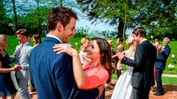 Clara (Jeannine Wacker, im VG) ist überglücklich, als Adrian (Max Alberti, im VG) sie bei der Hochzeitsfeier von Luisa (Magdalena Steinlein) und Sebastian (Kai Albrecht) zum Tanz auffordert.