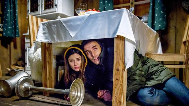 Bild: ARD/Christof Anrold Clara (Jeannine Wacker, l) und Adrian (Max Alberti) suchen unter einem Tisch Schutz vor der anrollenden Lawine.