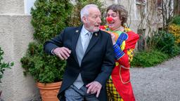 Der als Clown verkleidete Bela (Franz-Xaver Zeller) erlaubt sich einen Spaß mit Alfons (Sepp Schauer).
