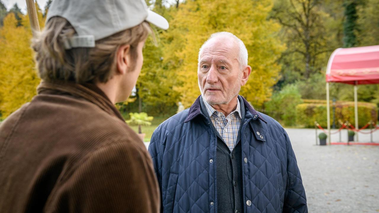 Gerry (Johannes Huth) setzt Alfons (Sepp Schauer) wegen Hildegards Rückkehr unbewusst unter Druck.