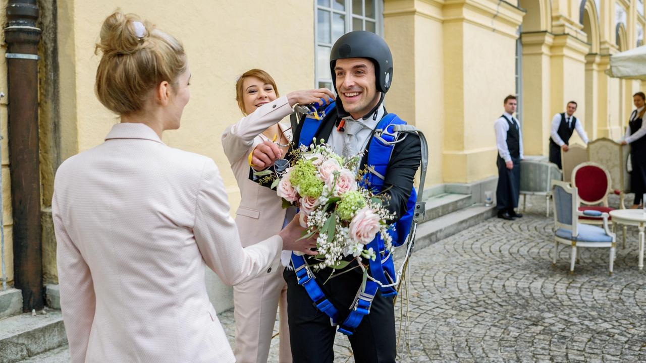 Wedding: Lo sposo è atterrato in ritardo.  Rebecca (Julia Alice Ludwig) e Ella (Victoria Reich) aiutano Adrian (Max Alberti) prima che il personale del castello stupito (sfondo, comparse) delle cinghie di parapendio.