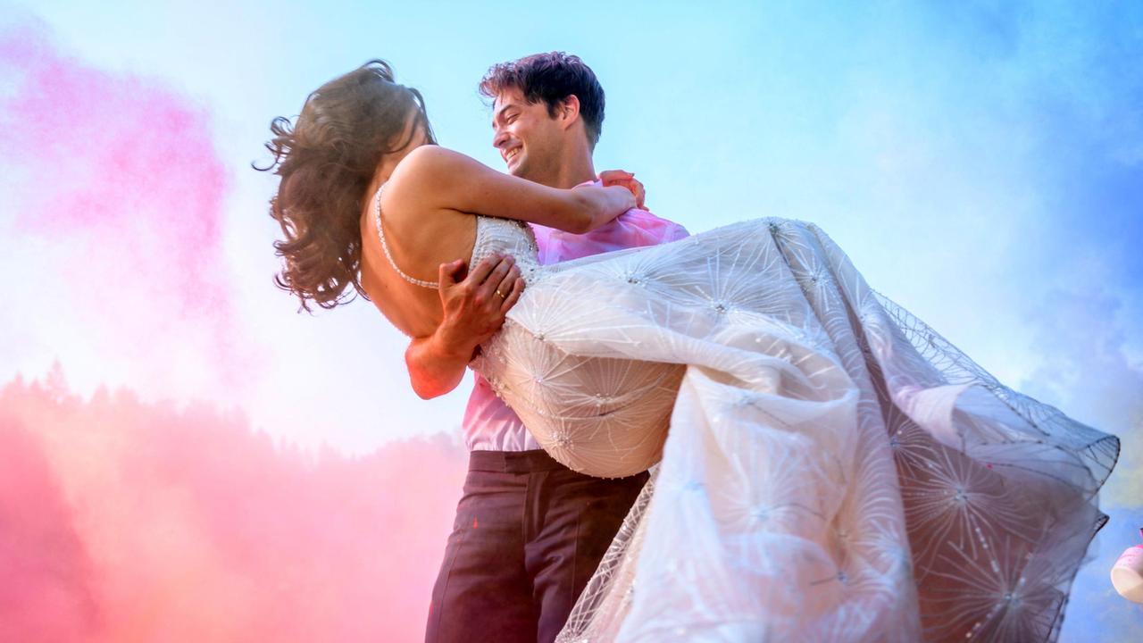 Matrimonio: in un fuoco d'artificio di colori, Joshua (Julian Schneider) indossa Denise (Helen Barke) per le mani.