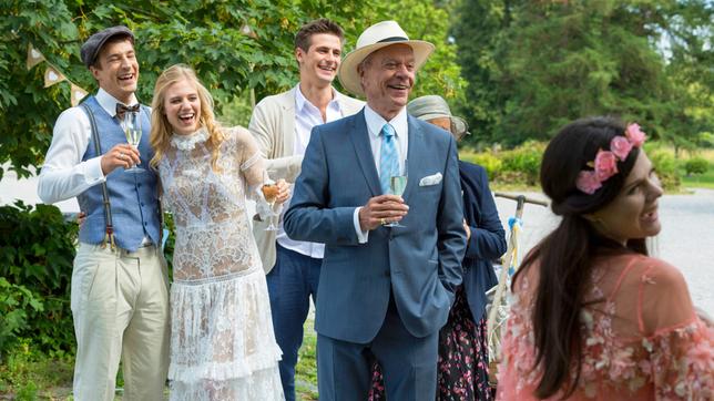 Bild: ARD/Stella Boda Hochzeit: Viktor (Sebastian Fischer), Alicia (Larissa Marolt), Paul (Sandro Kirtzel), Oma Anna (Doris Buchrucker) und Werner (Dirk Galuba, 2.v.r. mit Komparsin) bemerken amüsiert, wie sich Taifun bereits am Hochzeitsmahl bedient.
