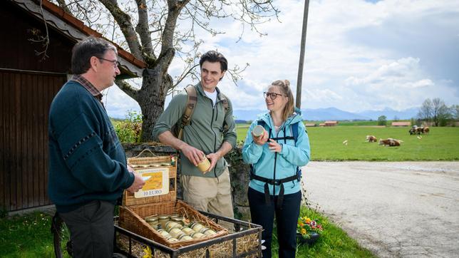 Leon (Carl Bruchhäuser) und Josie (Lena Conzendorf) kaufen bei ihrer Wanderung einen besondern Alpenrosenhonig. ARD/Christof Arnold (mit Komparse)