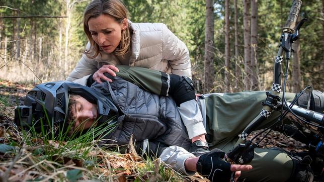 Bild: ARD/Christof Arnold Lia (Deborah Müller, h.) muss entsetzt mit ansehen, wie Benni (Florian Burgkart) beim Mountainbiken stürzt.