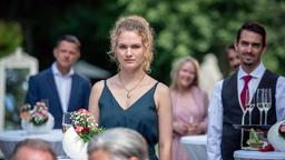 Maja (Christina Arends) beobachtet, wie Constanze Florian spontan einen Heiratsantrag macht (mit Komparsen).