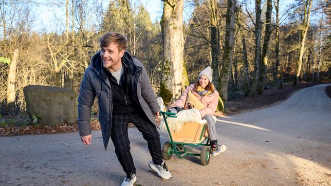 Max (Stefan Hartmann) versteht es Vanessa (Jeannine Gaspár) aufzumuntern, indem er sie vorsichtig mit einem Bollerwagen durch die Gegend fährt.