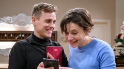 Max (Stefan Hartmann) zeigt Eleni (Dorothée Neff) stolz Bilder von Arthur.