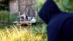 Robert (Lorenzo Patané, hinten) und Ariane (Viola Wedekind, hinten) werden bei ihrem romantischen Picknick beobachtet (mit Komparse).