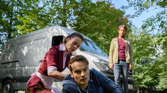 Bild: ARD/Christof Arnold Sebastian (Kai Albrecht) beobachtet, wie Alexandra (Kristina Dörfer) sich um den verletzten David (Michael N. Kühl) kümmert.