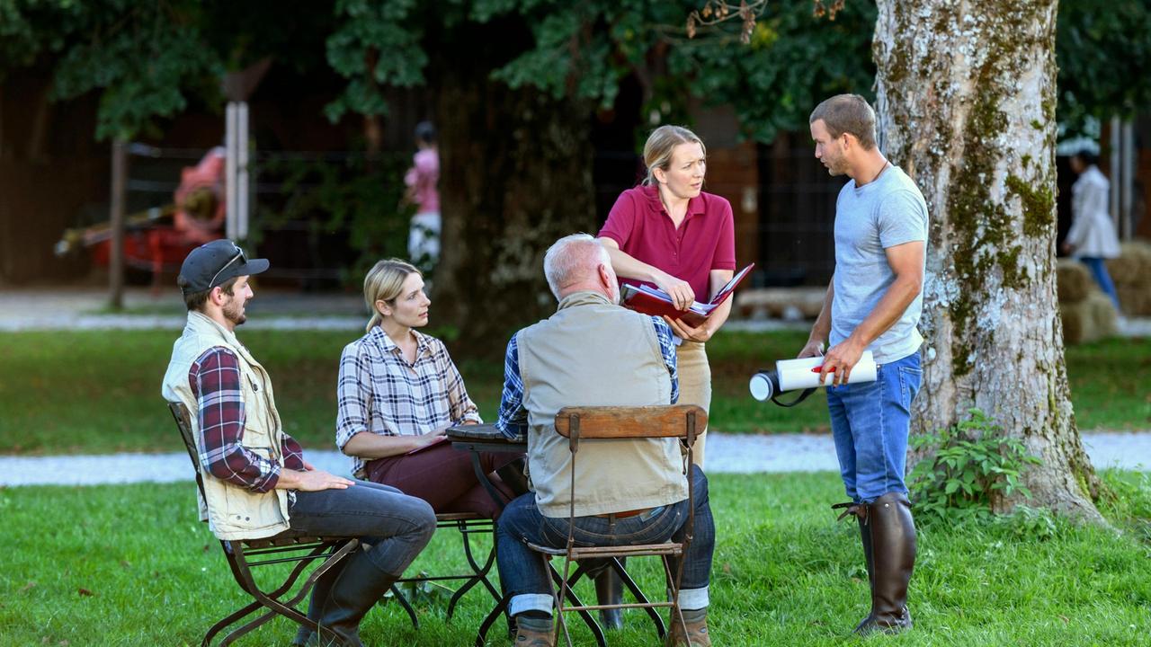 Selina (Katja Rosin) ist bei der Besprechung für das Polo-Turnier mit Tim (Florian Frowein) und Amelie (Julia Gruber) nicht ganz bei der Sache (mit Komparsen).