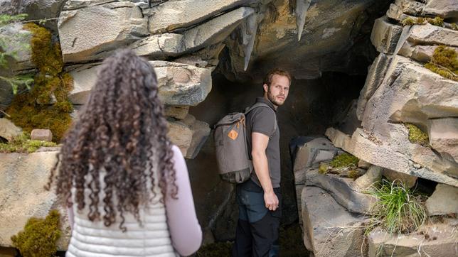 Shirin (Merve Çakır) gibt Florian (Arne Löber) ihren Glücksbringer mit, als dieser beschließt, alleine in der Höhle nach Maja zu suchen.