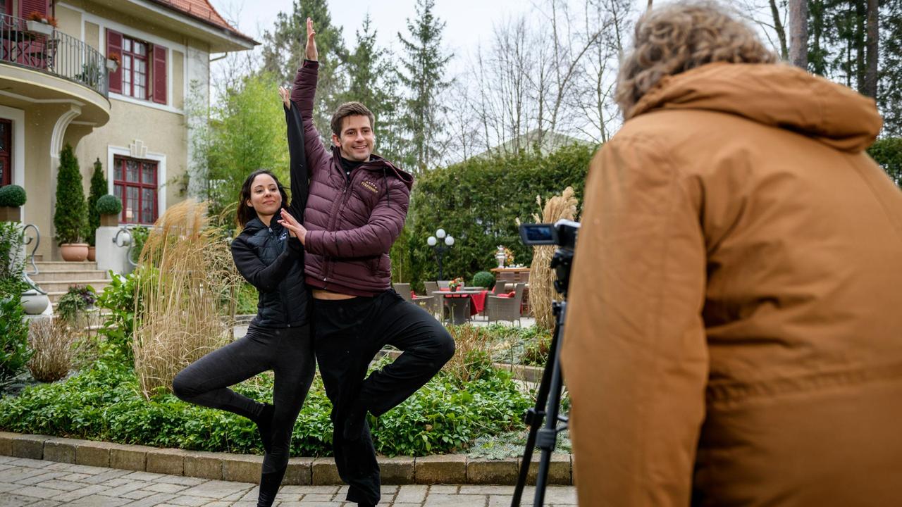 Vanessa (Jeannine Gaspár) und Paul (Sandro Kirtzel) werden von Bela (Franz-Xaver Zeller) für das Image-Video des Business-Laufs eingespannt.