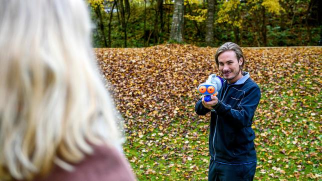 William (Alexander Milz) geht mit einer Wasserpistole auf Desirée (Louisa von Spies) los.