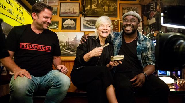 Bild: NDR/Morris Mac Matzen Gastgeberin Ina Müller begrüßt im Schellfischposten in dieser Sendung: Den Hundetrainer Martin Rütter und den Sternekoch Nelson Müller, sowie den Sänger James Arthur mit seiner Band und die Band Laing. Foto: Martin Rütter, Ina Müller, Nelson Müller.