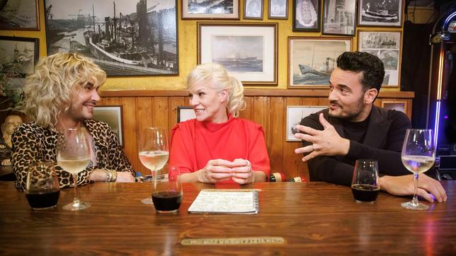 Bild: NDR/Morris Mac Matzen Gastgeberin Ina Müller begrüßt im "Schellfischposten" in dieser Sendung den Musiker Bill Kaulitz (Tokio Hotel) und den Musiker Giovanni Zarella. Foto: Bill Kaulitz, Ina Müller und Giovanni Zarella