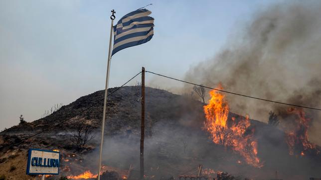 Bild: picture alliance/dpa/AP | Petros Giannakouris Flammen lodern auf einen Hügel. Trotz massiven Einsatzes von Löschflugzeugen und Helikoptern ist der Großbrand im Südosten der Insel Rhodos außer Kontrolle. Wie die Feuerwehr am 24.07.2023 mitteilte, flammte ein Brand um die Ortschaft Gennadi rund 60 Kilometer südöstlich von Rhodos-Stadt wieder auf.