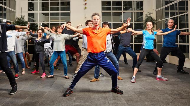 Bild: HR/sternfilm/Brad Wenner Alex Karp (Mitte) macht Thai Chi mit MitarbeiterInnen.