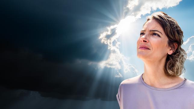 Bild: BR, Adobe Stock/Mr.Pancho Store, Hintergrund KI-erzeugt; Montage: BR Frau blickt Richtung Himmel, hinter ihr öffnen sich die Wolken und die Sonne schaut durch