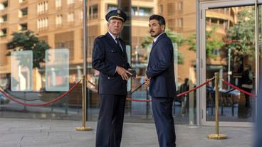 Bild: rbb/Marcus Glahn Der Direktor der Polizeiakademie Hans Lompert (Jörg Pose) trifft auf Kaya Kaymaz (Ercan Karaçayli). Beide warten auf die festliche Verleihung, in der Anton Willser zusammen mit seiner Kollegin Kirchhoff die Ernennungsurkunden vom Bundespräsidenten für das Bundesverfassungsgericht überreicht bekommen soll.