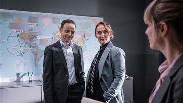 Bild: ARD Degeto/SRF/Pascal Mora Das Fedpol mischt sich ein: Jürg Wettstein (Elidan Arzoni, li.) und Anita Wegenast (Rachel Braunschweig) sprechenmit Kommissarin Isabelle Grandjean (Anna Pieri Zuercher).